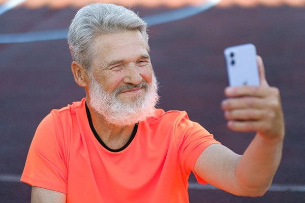Happy old man looking at his app telling him he has gained weight.